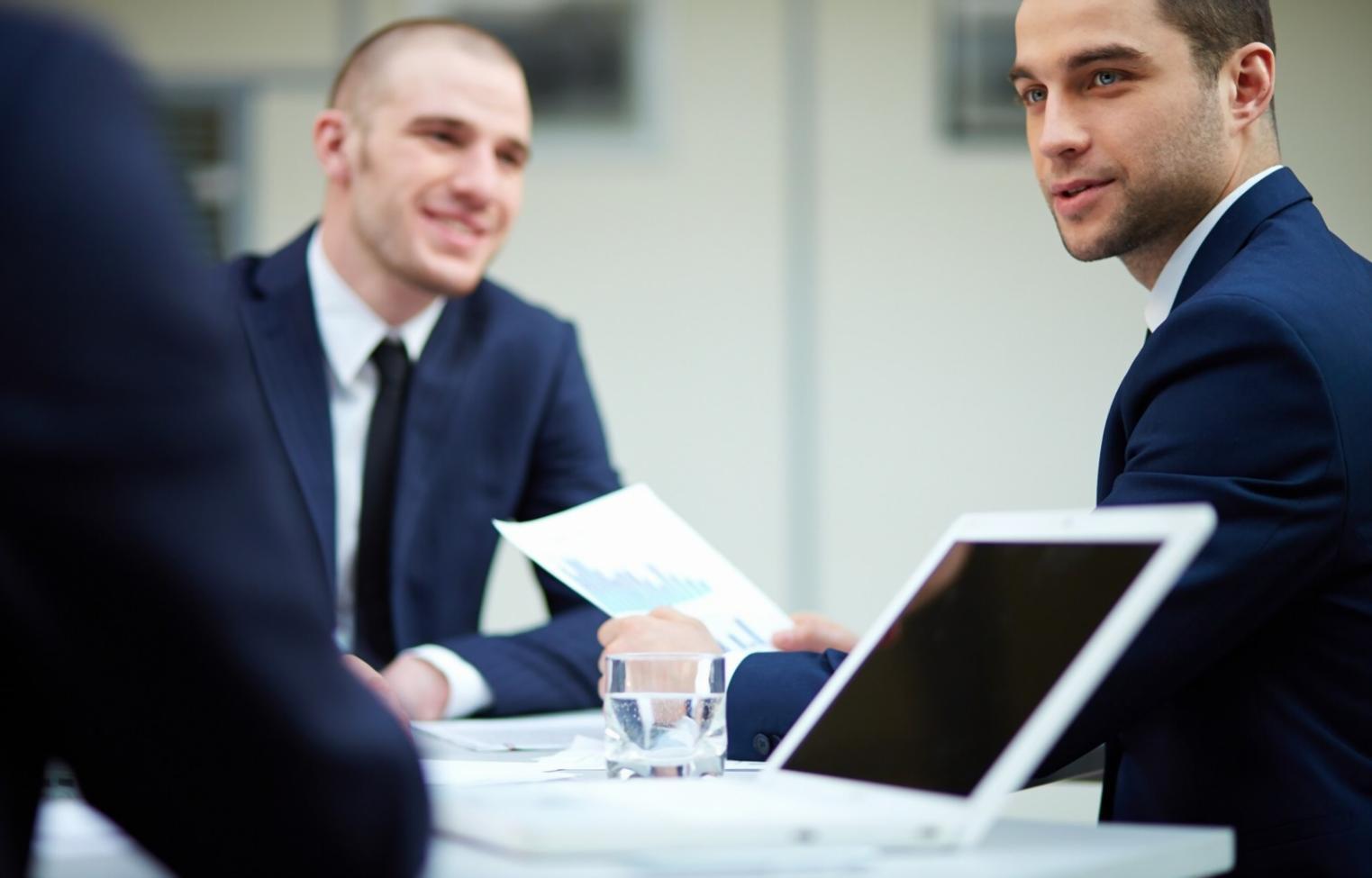Estudiante revisando presupuesto mensual en tablet con documentos financieros sobre mesa